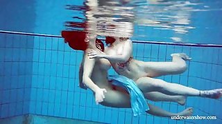 Girls in elegant dresses swimming underwater